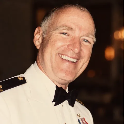 Portrait of Jim Hickerson, smiling, in Navy dress whites with a bow tie and medals.